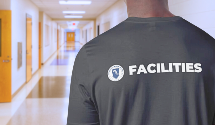  A man in a gray shirt displaying the word "facilities" prominently on the back, standing in a hall